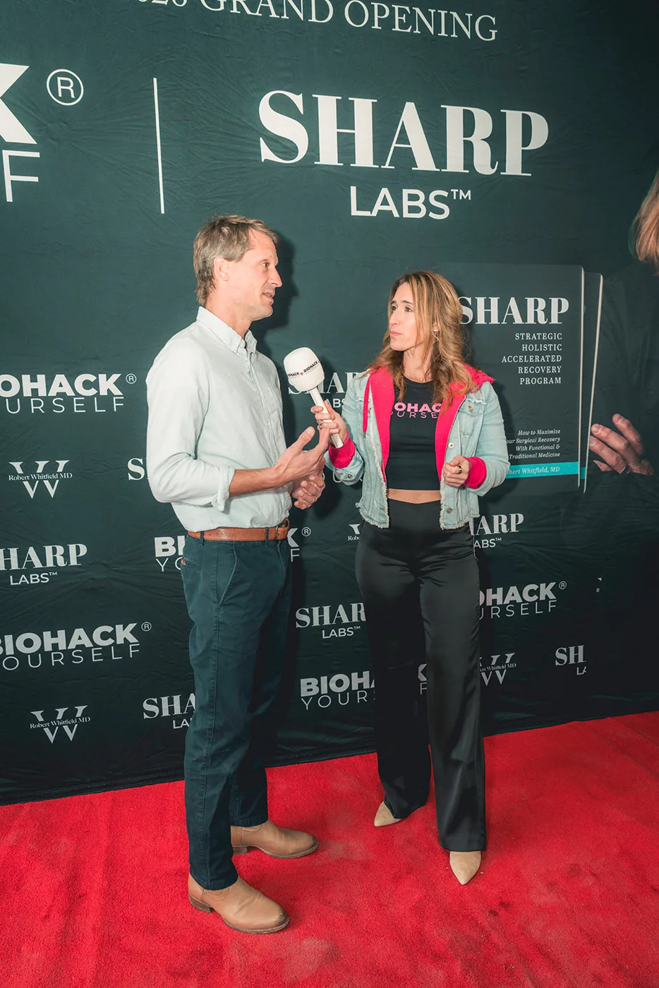 A Biohack Yourself journalist interviewing a guest at a client grand opening